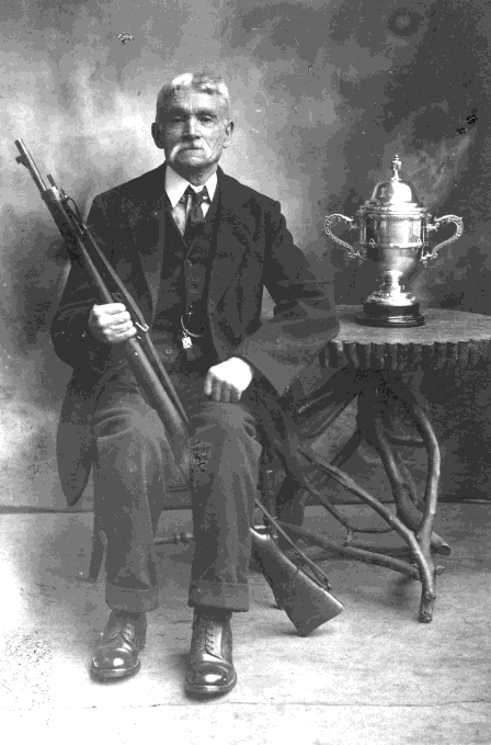 Portrait of a marksman with a rifle and trophy cup